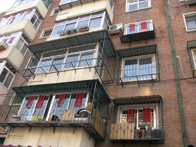 People hung red decorations on their windows and on their doorframes.