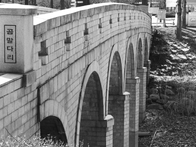 A bridge near across the river that goes through Olympic Park